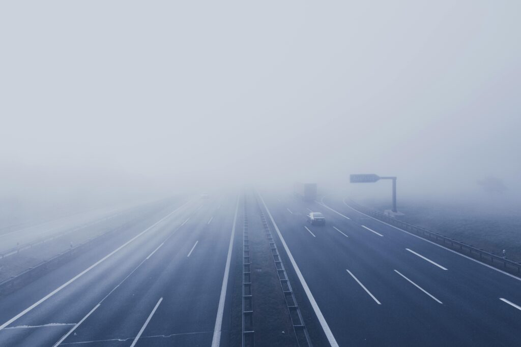 pexels-photo-226460-226460 A fog-covered highway with vehicles disappearing into the mist, creating a mysterious and tranquil scene.